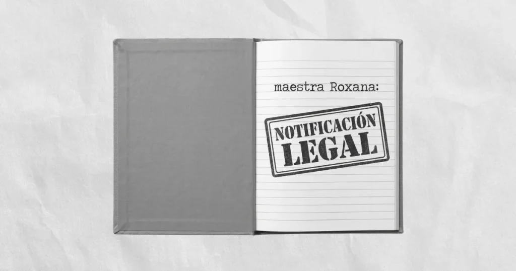 Fotografía cenital en escala de grises. Un cuaderno de comunicaciones escolar de tapa dura abierto descansa sobre un fondo de papel arrugado con textura. En la hoja con renglones se lee el encabezado "maestra Roxana:" y debajo destaca un enorme sello negro e inclinado con la frase "NOTIFICACIÓN LEGAL". Imagen conceptual sobre la tensión y los conflictos desproporcionados entre familias y docentes.