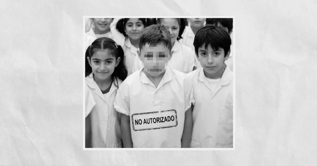 Fotografía en escala de grises de tres niños con uniforme escolar; el niño del centro tiene el rostro pixelado y un cartel en el pecho que dice "NO AUTORIZADO", sobre un fondo de papel arrugado.